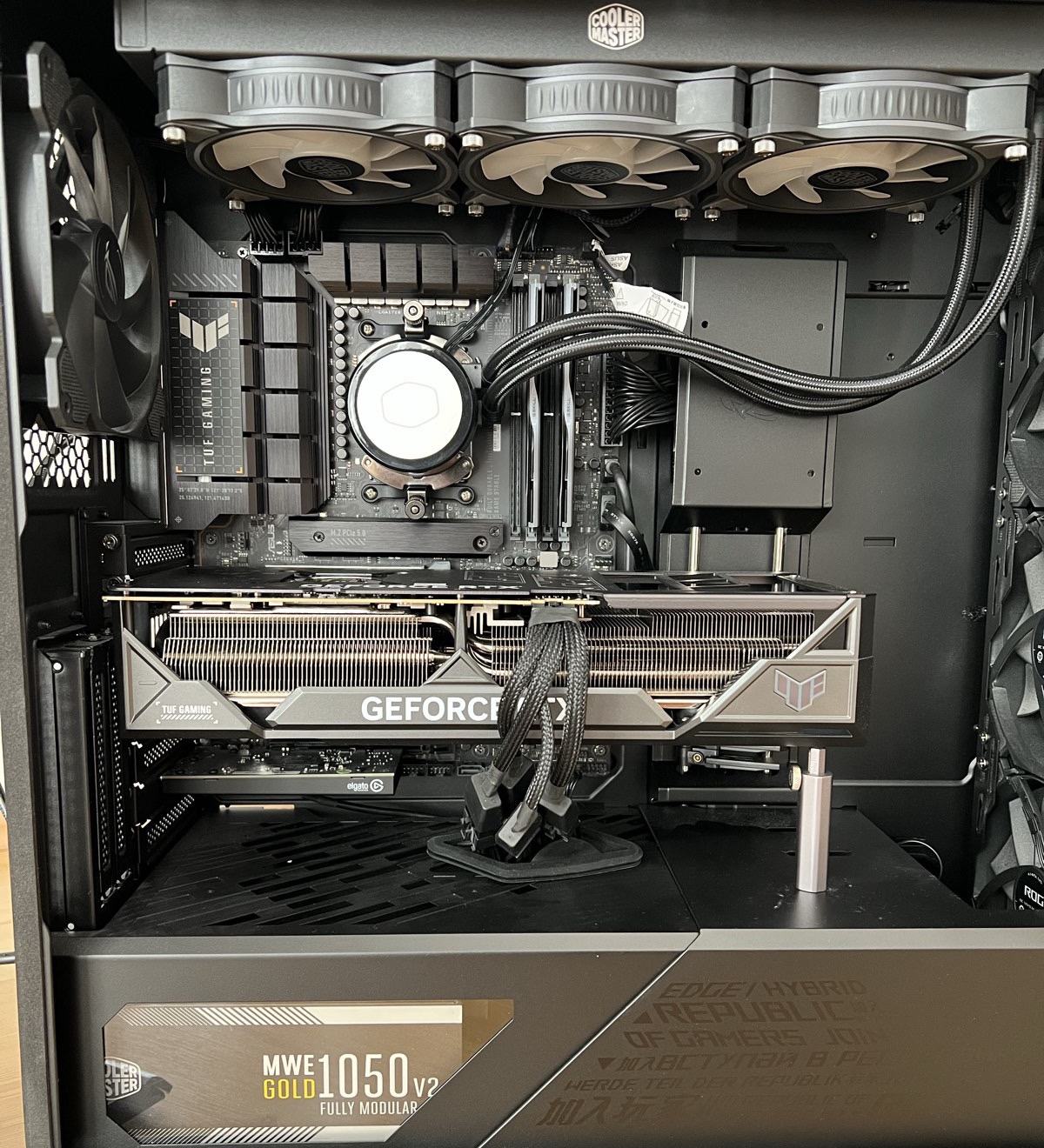 The full build with the side panel off: the RTX 4090 across the middle, the radiator and fans on top, the power supply below
