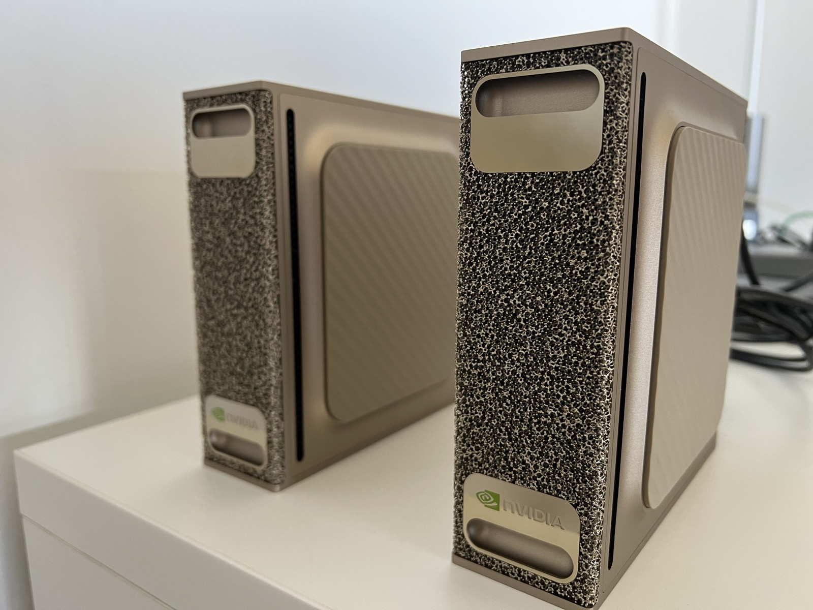 Two DGX Sparks standing upright side by side on a white shelf